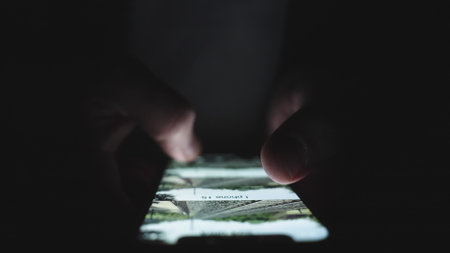 Man swiping on the screen while using smartphone in the dark. Slow motionの写真素材