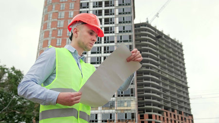 Construction inspector is consulting checklist during building object inspectionの写真素材