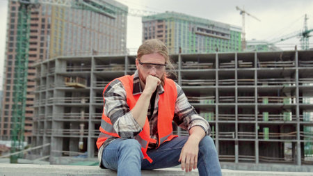 Portrait of tired builder resting after workの写真素材