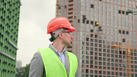 Architect inspects territory of construction site outside