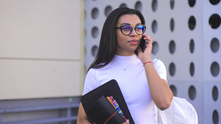 Busy lady with mobile phone near buildingの写真素材