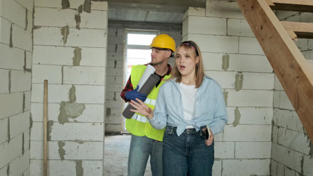 Site supervisor and contractor inspecting dwelling house under constructionの写真素材