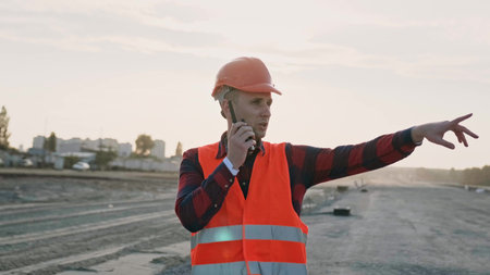 Professional foreman talking with worker via radio set