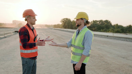 Smiling builders talking, controlling work process at sectorの写真素材