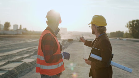 Architect holding blueprint and discuss with builderの写真素材