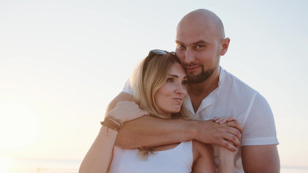 Happy young man hugging his girlfriend on the sea coast