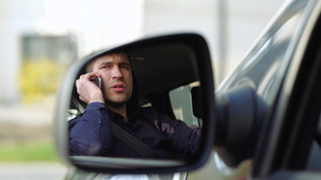 Young man inside car. Slow motion of businessman talking on phone and argue. Serious concentrated...