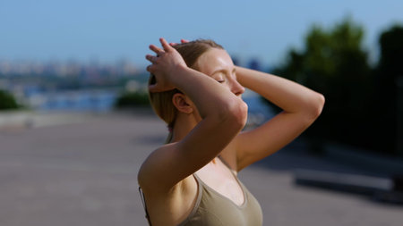 Caucasian young beautiful fit sportswoman standing outside on sunny summer day. Close up. Pretty happy attractive athletic female on street in city after workout. Sport activity conceptの写真素材