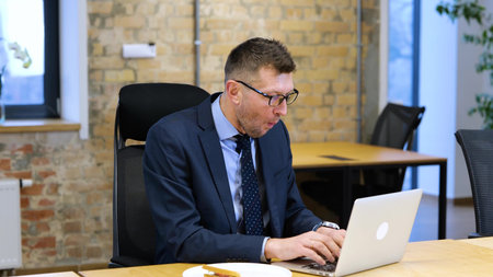 video. Middle age Caucasian man is sitting in the office, working on computer.