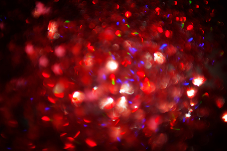 Dark red Festive blur background. Abstract night twinkled bright background with bokeh defocused golden lights. Christmas blurry boke lightsの写真素材