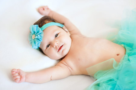 Happy newborn baby girl with hands up