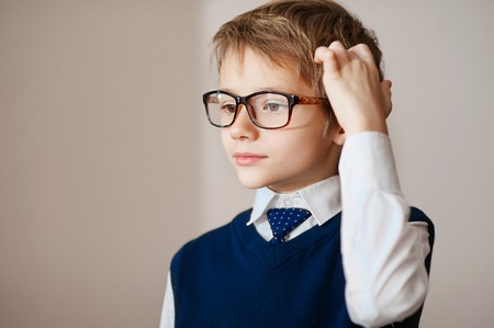 Thinking child portrait of a little boy age seven in glasses  deeply about something looking up copy space above his headの写真素材