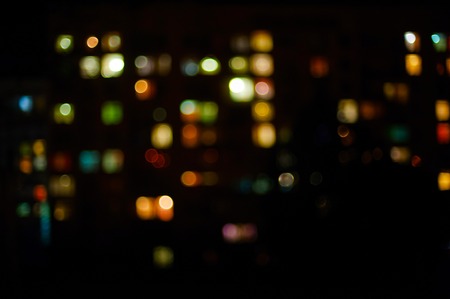 glowing windows of houses at night in the city. The image is not in focus, beautiful bokehの写真素材