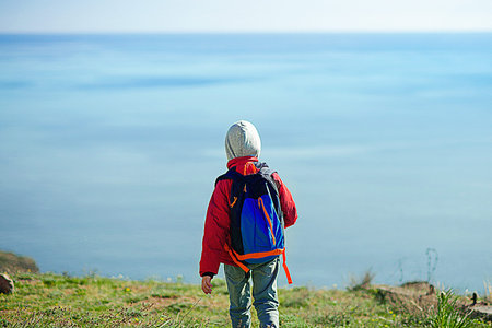 Child standing in front of a seascape