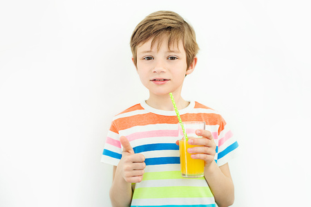 Little blonde boy is going to drink a fresh orange juiceの写真素材