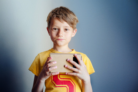 The boy is holding virtual reality goggles, VR, blue backgroundの写真素材