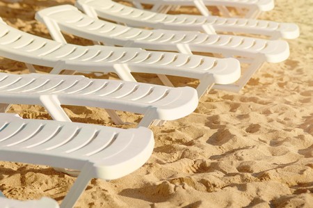 Beach chairs on the sand. Several free white beach chairs on the beachの写真素材