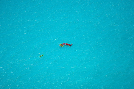 kayakers swimming through the crystal waters, Sunny day, natural light and reflections on a...