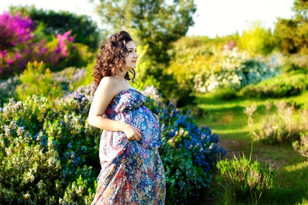 Pretty Pregnant woman posing in a green rosemary gardenの写真素材