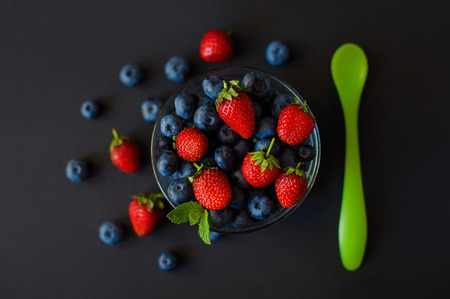 Fresh berries. Various summer berries in a bowl on rustic wooden table.の写真素材
