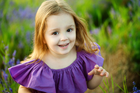 Cute little girl on the meadow in spring dayの写真素材