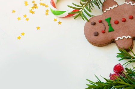 Christmas, Eve. Celebratory background. Gingerbread man, fir tree branches, sprouts on a white...