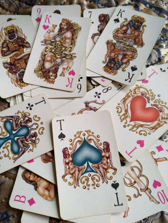 A deck of playing cards is scattered over the bedspread.のeditorial素材