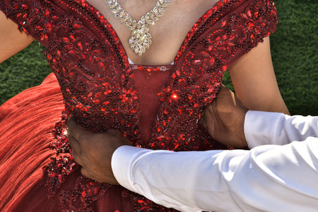 A scarlet dress is on the bride, the hands of the groom's man are holding the girl by the waist. No...