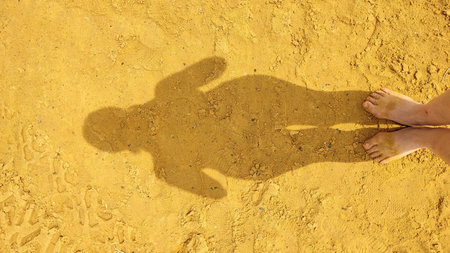 shadow of a woman on yellow sand, abstraction of a man. high quality photo