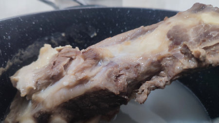 boiled meat on a black frying pan, food cooking. High quality photoの写真素材