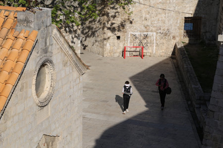 Dubrovnik, Croatia, old town, tiled roof of a house ancient stone building with a triangular facade, top view, people tourists walking April 22, 2023. High quality photoの写真素材