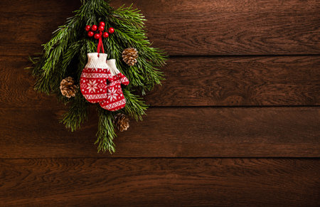 Merry Christmas and Happy New Year! Mittens, fir branches and cones on a wooden backgroundの写真素材