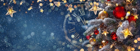 Christmas tree with baubles in a blue night - decorations on fir branches with shiny and defocused lights and snowflakes on an abstract backgroundの写真素材