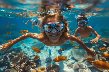 Underwater view of happy kids snorkeling in coral reefの素材