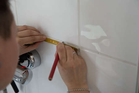 a woman is renovating a bathroom with toolsの写真素材