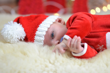 Portrait of a newborn baby in Christmas clothes and Santa hat.の写真素材