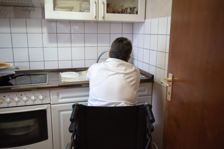 a disabled woman in a wheelchair washes dirty dishes