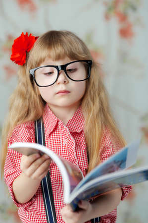 Adorable, young girl with red flowerの写真素材
