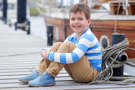 Kid in striped sweater on a pierの写真素材