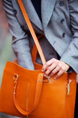 Fashion, vogue. Woman with orange bag outdoorの写真素材