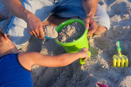 Father plays with his son on the beachの写真素材