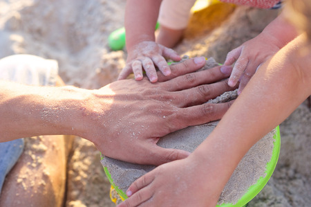 Kids playing with sand on the beachの写真素材