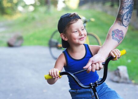 Childhood, family. Adorable boy with a bikeの写真素材