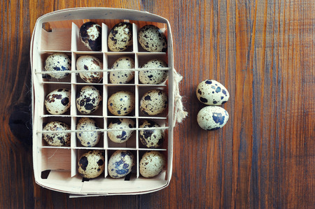 Quail eggs in wooden box, packaging, tray on wooden backgroundの写真素材