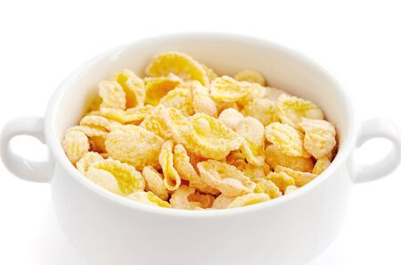 Cornflakes in bowl on white backgroundの写真素材