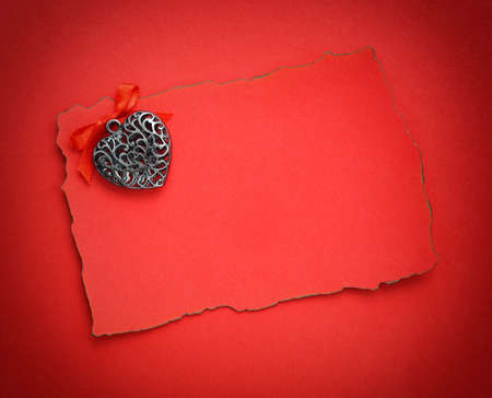 Decorative hearts are on the sheet of red paperの写真素材