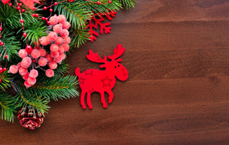 Christmas figurine elk and spruce twigs on a wooden backgroundの写真素材