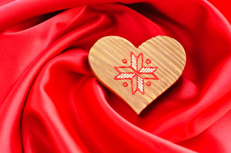 Wooden Heart on red satin backgroundの写真素材
