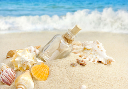 Summer sandy beach concept with letter in bottleの写真素材