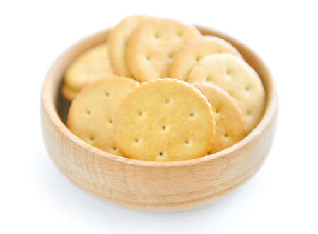 Crackers in a wooden bowl on white backgroundの写真素材